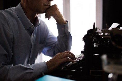 One hand typing thoughtful